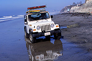 White Jeep Wrangler with surfboard on top, loud speaker at front … Lifeguards at Encinitas