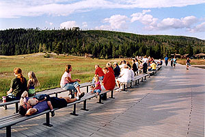 Old Faithful geyser on the left â€¦ people awaiting another scheduled eruption