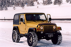 yellow Jeep Wrangler at overview of Dillon Lake