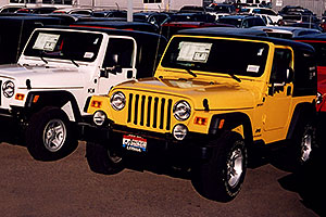 white 2006 Jeep Wrangler X and yellow Wrangler Sport at Lithia Jeep