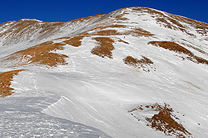 hiker and dog walking down east face of Loveland Pass