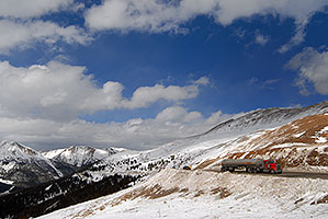 red semi truck approaching top of Loveland Pass from Denver side