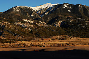 Two People in the last rays of sunshine at Great Sand Dunes
