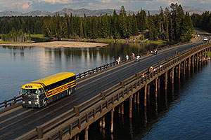 Yellow Yellowstone Park bus on Fishing Bridge, over Yellowstone River