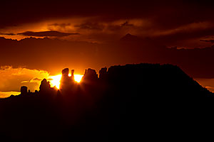 Sun setting behind rock formations in Sedona